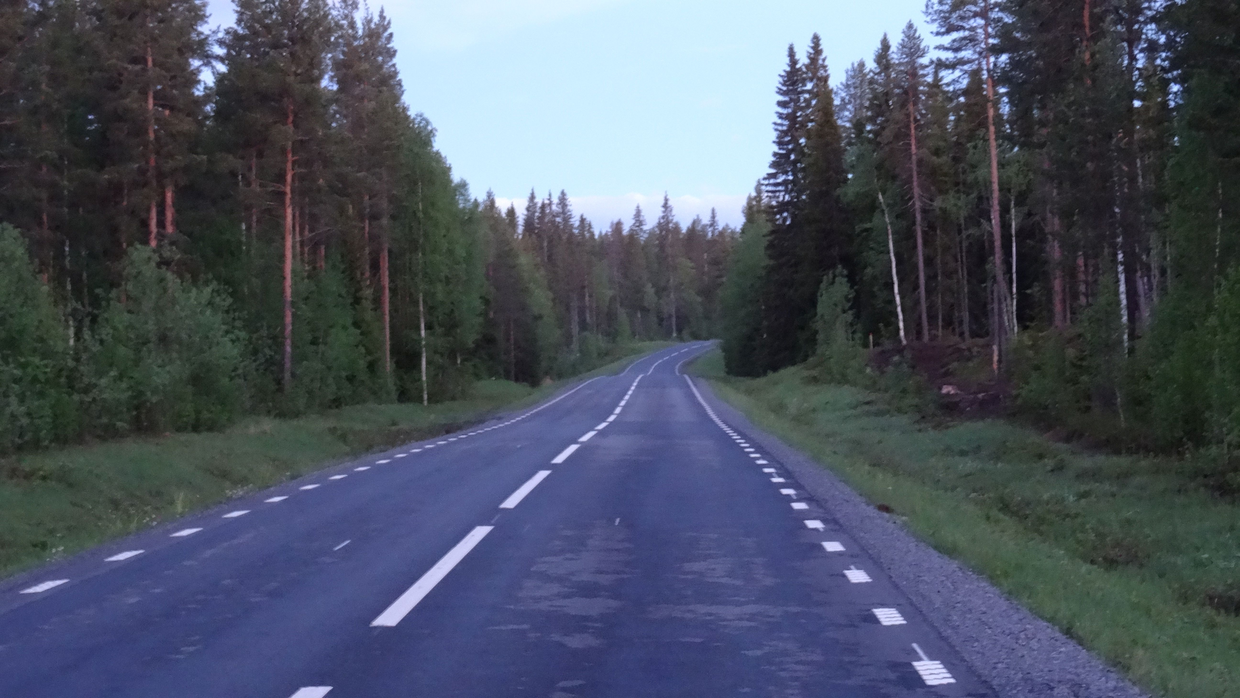Een weg dwars door het bos zoals de meeste wegen in Lapland (Zweden)